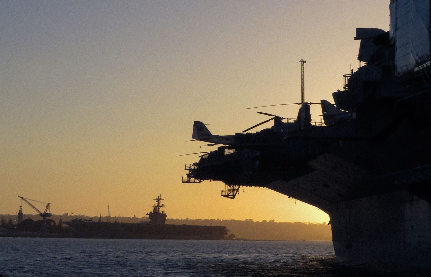 Navy aircraft carrier silhouetted at dusk