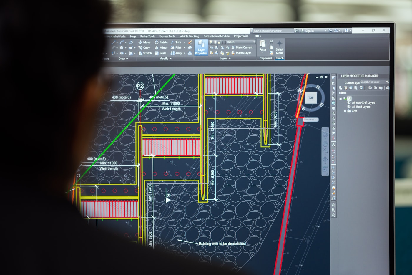 Engineer reviewing a detailed CAD blueprint on screen